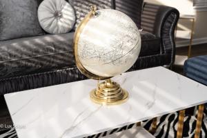 einen goldenen Globus auf einem weißen Tisch vor einer Couch in der Unterkunft Luxury 3 Bedrooms with King bed Downtown Indy in Indianapolis