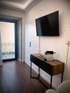 um quarto com uma secretária e uma televisão na parede em BLUE ANCORA HOTEL em Vila Praia de Âncora