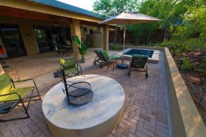 a patio with a table and chairs and an umbrella at Bee-Eater Cottage in Hoedspruit