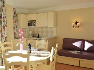a kitchen and dining room with a table and a couch at Appartement 6 couchages avec piscine et parking aux Issambres - FR-1-226-386 in Les Issambres