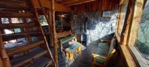 una vista interior de una cabaña con 2 sillas y un banco en Tres Continentes, en San José de Maipo