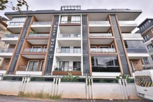 an apartment building with a sign on it at Апартаменты Best Home 26 Cleopatra Legacy No 8 in Alanya