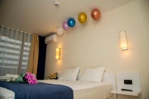 um quarto com duas camas com balões na parede em DOWNTOWN Centre in BATUMI APARTHOTEL ORBI City em Batumi