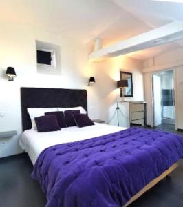 um quarto com uma cama grande e um cobertor roxo em Duplex 1er étage résidence "Pouchkine" centre Bayeux jardin aménagé commun proche des plages du débarquement parking gratuit à proximité em Bayeux