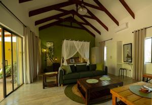 Bee-Eater Cottage في هويدزبروت: غرفة معيشة مع أريكة خضراء وطاولة