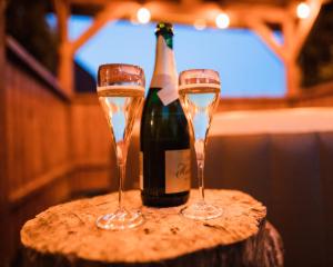 due bicchieri di champagne su un tavolo con una bottiglia di vino di Cottage in Domasa 2 