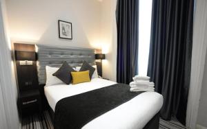 a bedroom with a bed with black and yellow pillows at The 29 London in London