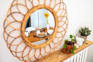 a mirror on a shelf with plants and flowers at Studio cosy - Espace extérieur et proche du centre in Annecy