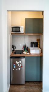 a small kitchen with a stainless steel refrigerator at Studio cosy - Espace extérieur et proche du centre in Annecy +6 photos