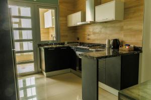 a kitchen with black counters and white cabinets at Alta Vista Apart Alojamiento Temporario Reconquista in Reconquista
