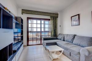a living room with a couch and a tv at Balcon del Mar 496 in Costa Del Silencio