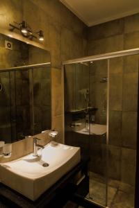 y baño con lavabo y ducha. en ALTA VISTA APART HOTEL en Reconquista