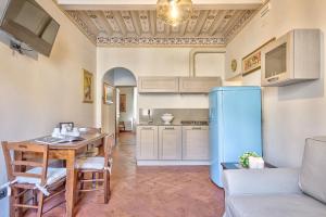 eine Küche mit einem Tisch und einem blauen Kühlschrank in der Unterkunft Casa Sofia - Together in Tuscany in Cortona