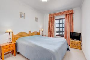 um quarto com uma cama grande e uma televisão em Balcon del Mar 496 em Costa Del Silencio