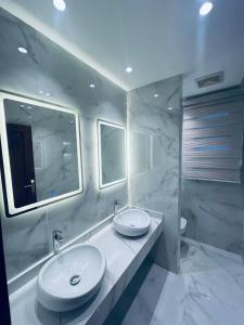 ein Badezimmer mit zwei Waschbecken und einem großen Spiegel in der Unterkunft شقة تشطيب فندقي موقع متميز عائلات فقط in Kairo
