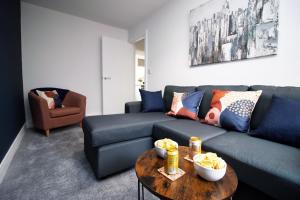 a living room with a blue couch and a table at K Suites - Seymour Street in Mountain Ash