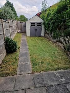 a backyard with a fence and a garage at Charming 2 Bed House - Family Friendly in Nottingham