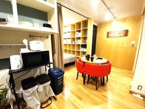 a living room with a table and a red chair at 港区南麻布・戸建タイプ・ファミリー・8人まで・無料Wi-Fi in Tokyo