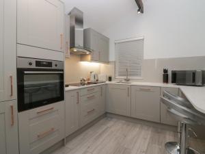 a kitchen with white cabinets and a stove top oven at Eden on the Crescent in Morecambe