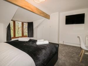 a bedroom with a bed and a tv and a chair at Eden on the Crescent in Morecambe