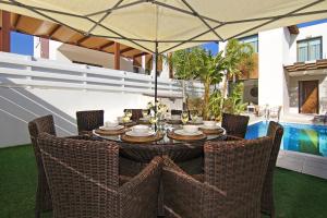 een tafel met stoelen en een parasol op een patio bij Villa Maris in Protaras