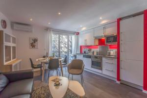a kitchen and living room with a table and chairs at Alberts Cocooning in Grenoble
