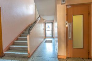 a hallway with stairs in a building with a yellow door at Alberts Cocooning in Grenoble