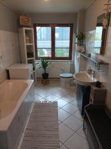 a bathroom with two sinks and a tub and a toilet at Ferienwohnung zur Alten Brauerei, free Wi-Fi+Parken, 3 Schlafzimmer, Grillecke in Lehesten