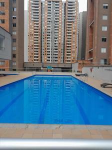 a large blue swimming pool with tall buildings in the background at Apartamento inigualable en la ciudad de Medellín excelente vista piso 25 in Medellín