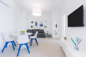 a white living room with a table and chairs at Puolo Seaside Apartment 2 in Massa Lubrense