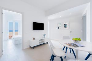 a white living room with a white table and chairs at Puolo Seaside Apartment 2 in Massa Lubrense +8 photos