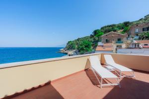 two chairs sitting on a balcony overlooking the ocean at Puolo Seaside Apartment 2 in Massa Lubrense