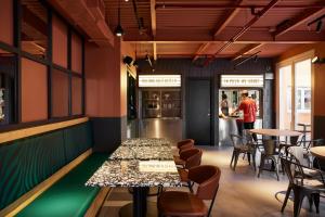 a restaurant with tables and chairs and people in the kitchen at JO&JOE ROMA in Rome