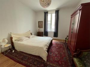 um quarto com uma cama branca e um tapete vermelho em Appartement cœur de Ville Vichy em Vichy