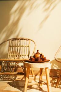 a bowl of fruit on a table next to a chair at Phòng Chôm Chôm (Rambutan Room) - Nhà Mơ Homestay Bến Tre in Ben Tre