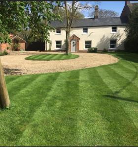 a house with a large lawn in front of it at The Paddocks in Moulton Chapel