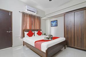 Qualia Homes Kondapur في Kondapur: غرفة نوم بسرير ومخدات حمراء