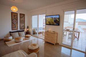Una sala de estar con un sofá, un televisor y una mesa. en Apartamento Maravilla Tropical - La Herradura, en Almuñécar