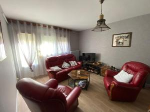 a living room with two red chairs and a table at CHEZ NOUS BIS in Commercy