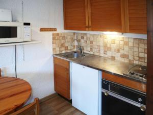 una piccola cucina con lavandino e forno a microonde di Appartement Les Orres, 1 pièce, 4 personnes - FR-1-322-170 a Les Orres