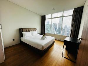 Vortex Suites KLCC by Nadia Guesthouse Kuala Lumpur في كوالالمبور: غرفة نوم بسرير ونافذة كبيرة