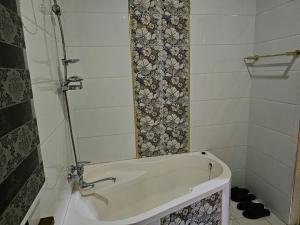 a white bath tub in a small bathroom at Elite Hotel in Tashkent
