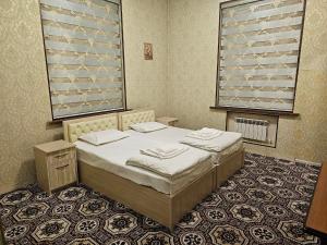 a bedroom with a bed and a large window at Elite Hotel in Tashkent