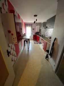 a kitchen with red cabinets and a table in it at CHEZ NOUS BIS in Commercy