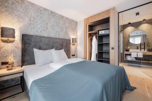 a bedroom with a blue bed and a mirror at MYALPS Tirol in Oetz