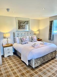 een slaapkamer met een groot bed met witte lakens bij Scottish Equi B&B in Lanark