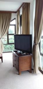 a living room with a flat screen tv on a dresser at Marina Beach Guest house in Southbroom