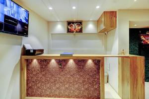 a room with a counter and a tv on a wall at Prince NX Hotel in Thane
