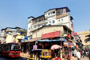 a busy city street with a building and a bus at Prince NX Hotel in Thane