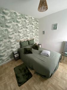 a bedroom with a bed and a wall with a leaf pattern at CHEZ NOUS BIS in Commercy